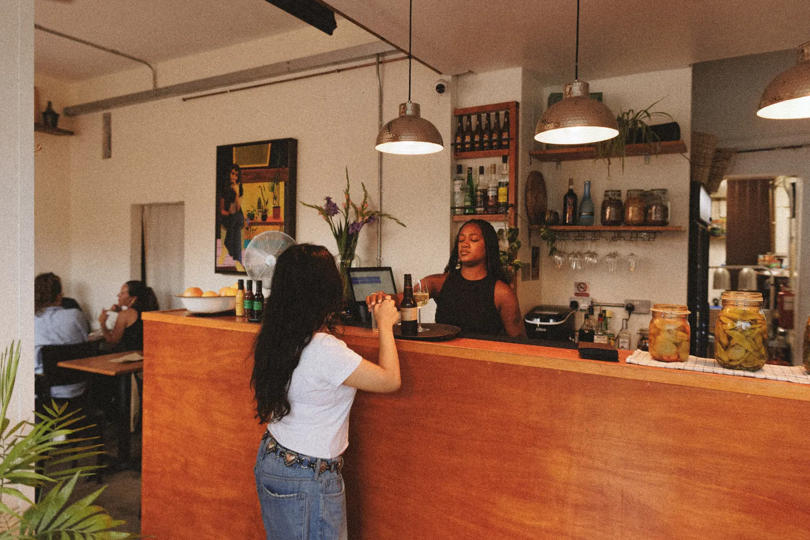 A bartender serving a customer at the Mauby bar
